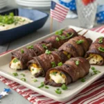Grilled beef-wrapped jalapeño poppers stuffed with cheese, arranged on a festive 4th of July tray with patriotic decorations in the background.